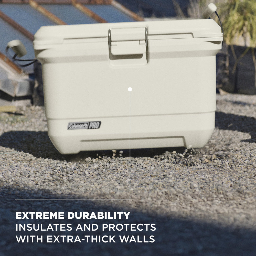 Coleman Pro cooler secured in a truck bed with straps for steady transport.