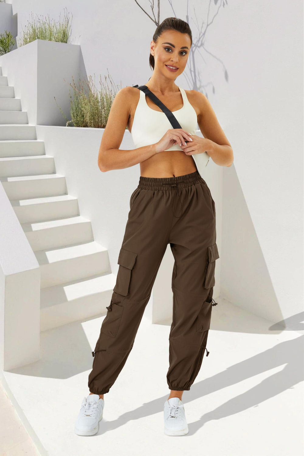COPYLEAF women's parachute cargo pants offer elastic waistband and cuffs for versatile fit.