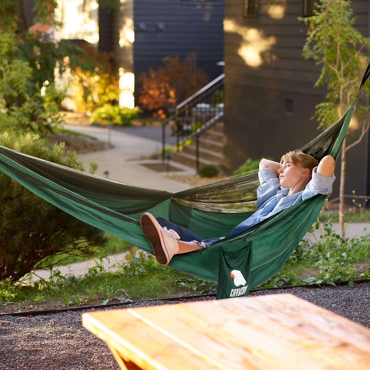 Covacure camping hammock demonstrates 772 lbs capacity in a scenic outdoor setting.