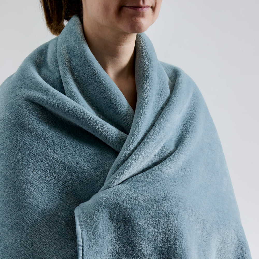 Cuddledown travel blanket stored in its bag with adjustable strap for easy carry.