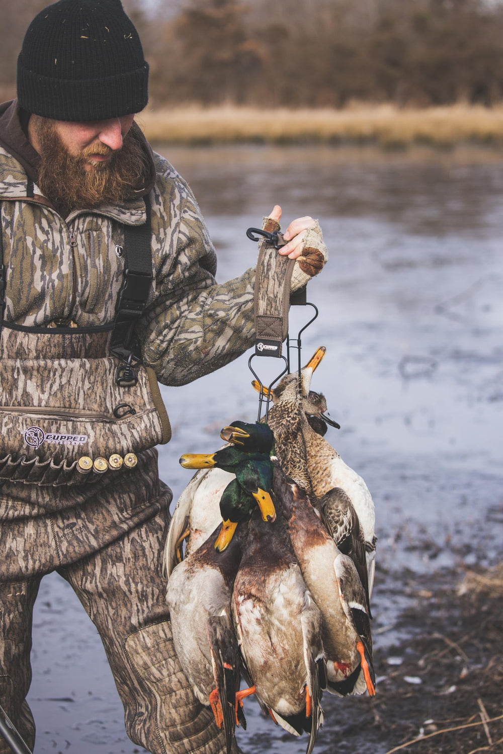 Cupped Waterfowl duck strap in Mossy Oak Bottomland camo keeps gear discreet in reeds
