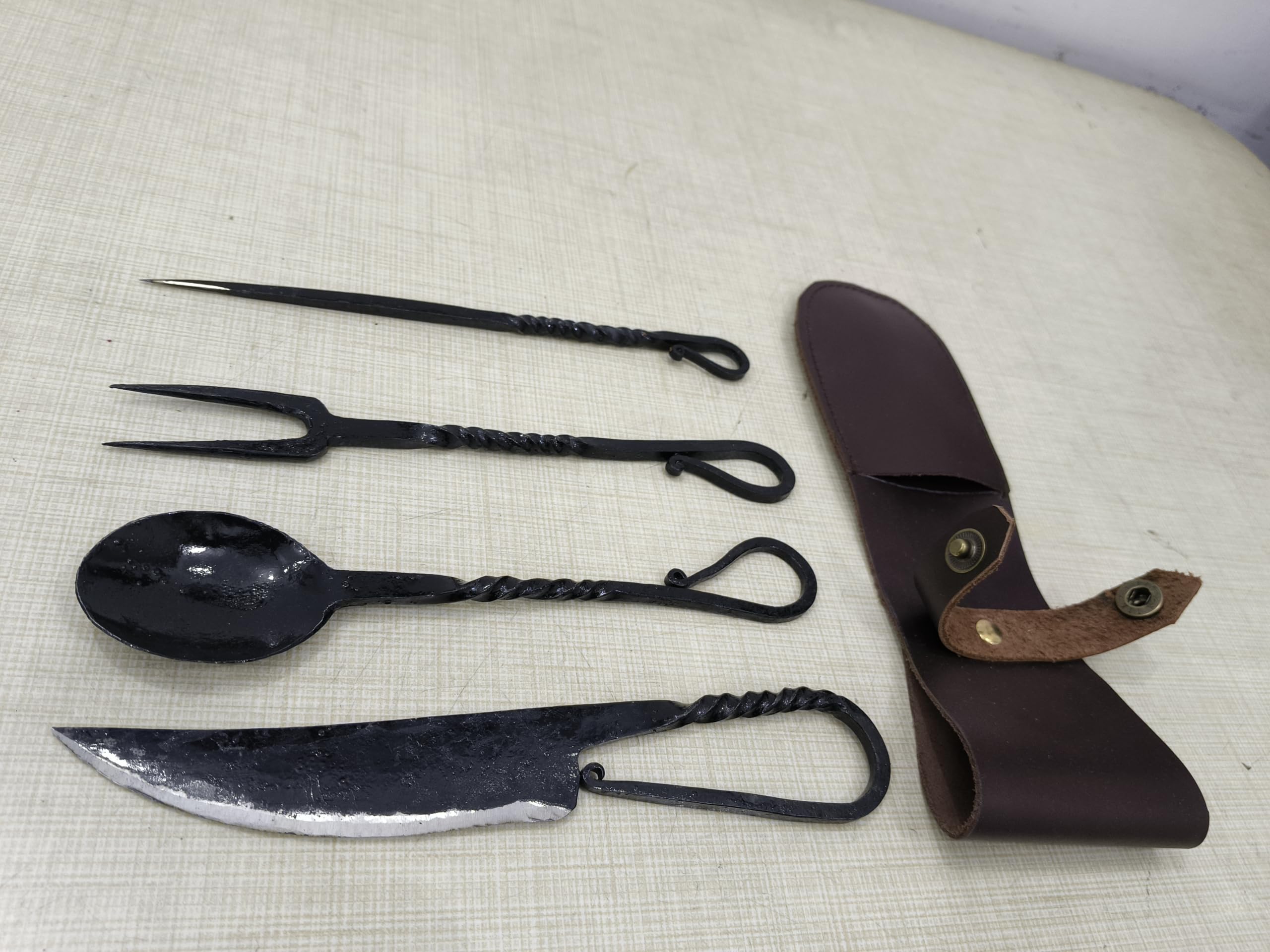 Cutlery Set Spoon and fork close-up highlights hand-forged texture and black finish.