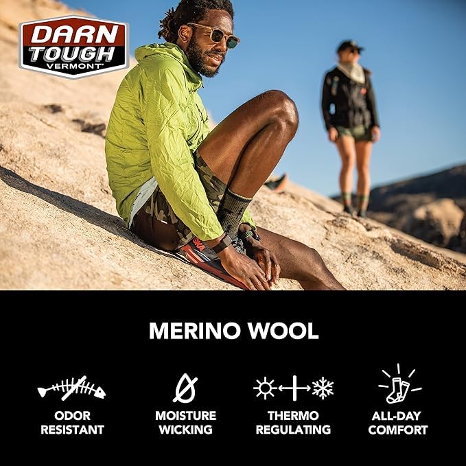 Model wearing Darn Tough socks inside hiking boots showing secure boot-height fit.