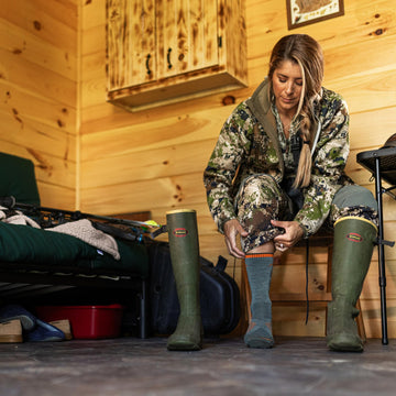 Darn Tough Vermont boot socks seafoam shown worn in rugged outdoor boots for hunting
