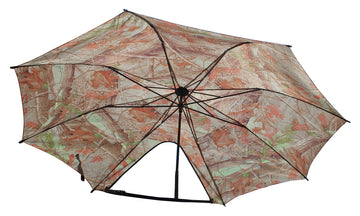Dead Ringer Tree Stand Umbrella camo mounted to a tree shielding rain.