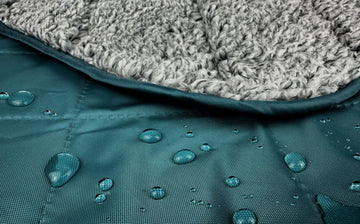 Down Under Outdoors teal-backed blanket shown on bleachers for windproof warmth at games.