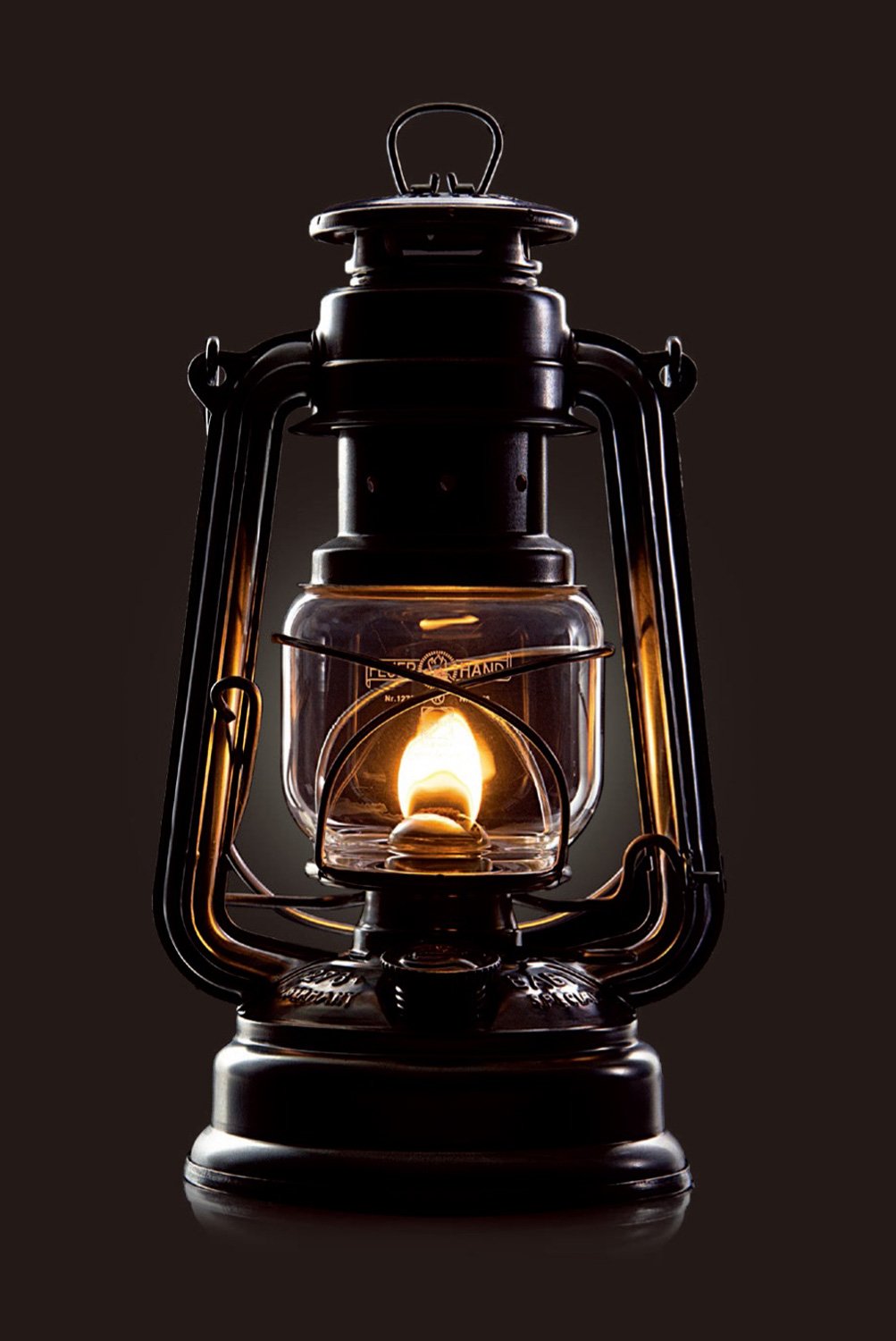 Feuerhand Baby Special 276 olive lantern at dusk with warm glow.