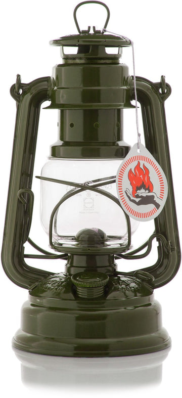 Feuerhand Baby Special 276 olive lantern on table, cozy outdoor lighting setup.