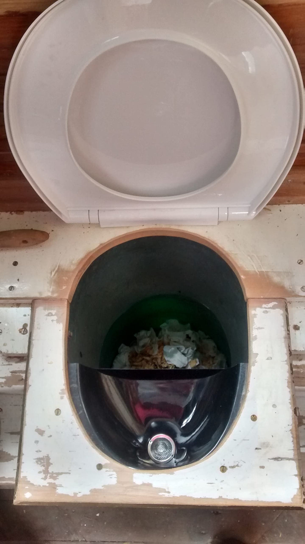 Free Range Designs urine diverter cleaning shows glossy surface and removable metal filter.