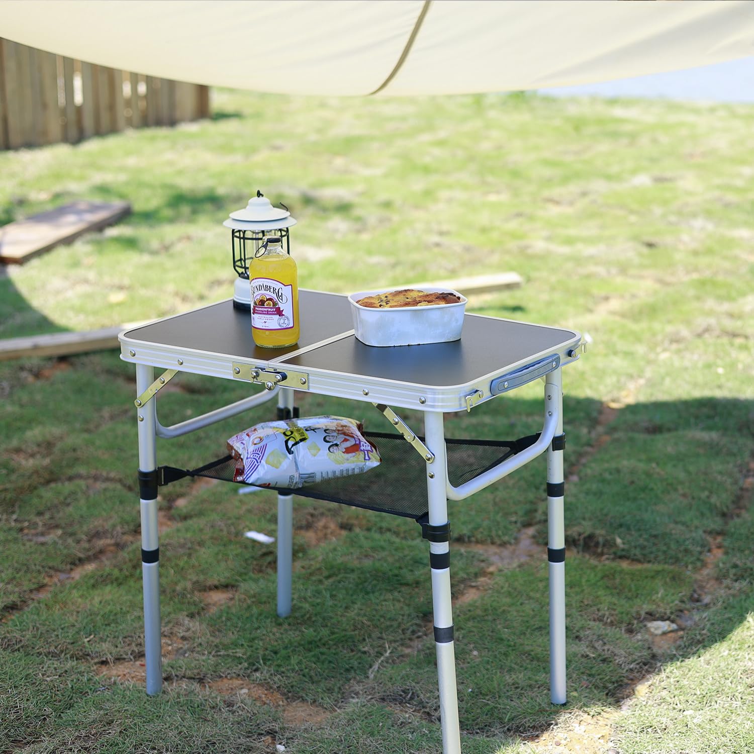 Geastsheng portable camping table extended-height-236 shows adjustable legs on uneven ground for stable use.
