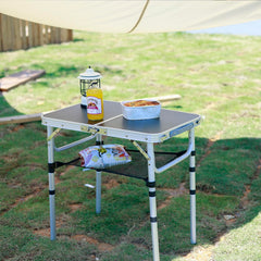Geastsheng portable camping table extended-height-236 shows adjustable legs on uneven ground for stable use.