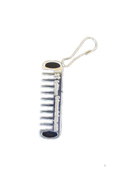 Grim Workshop Comb Micro Tool mounted on a backpack zipper for on-demand grooming.
