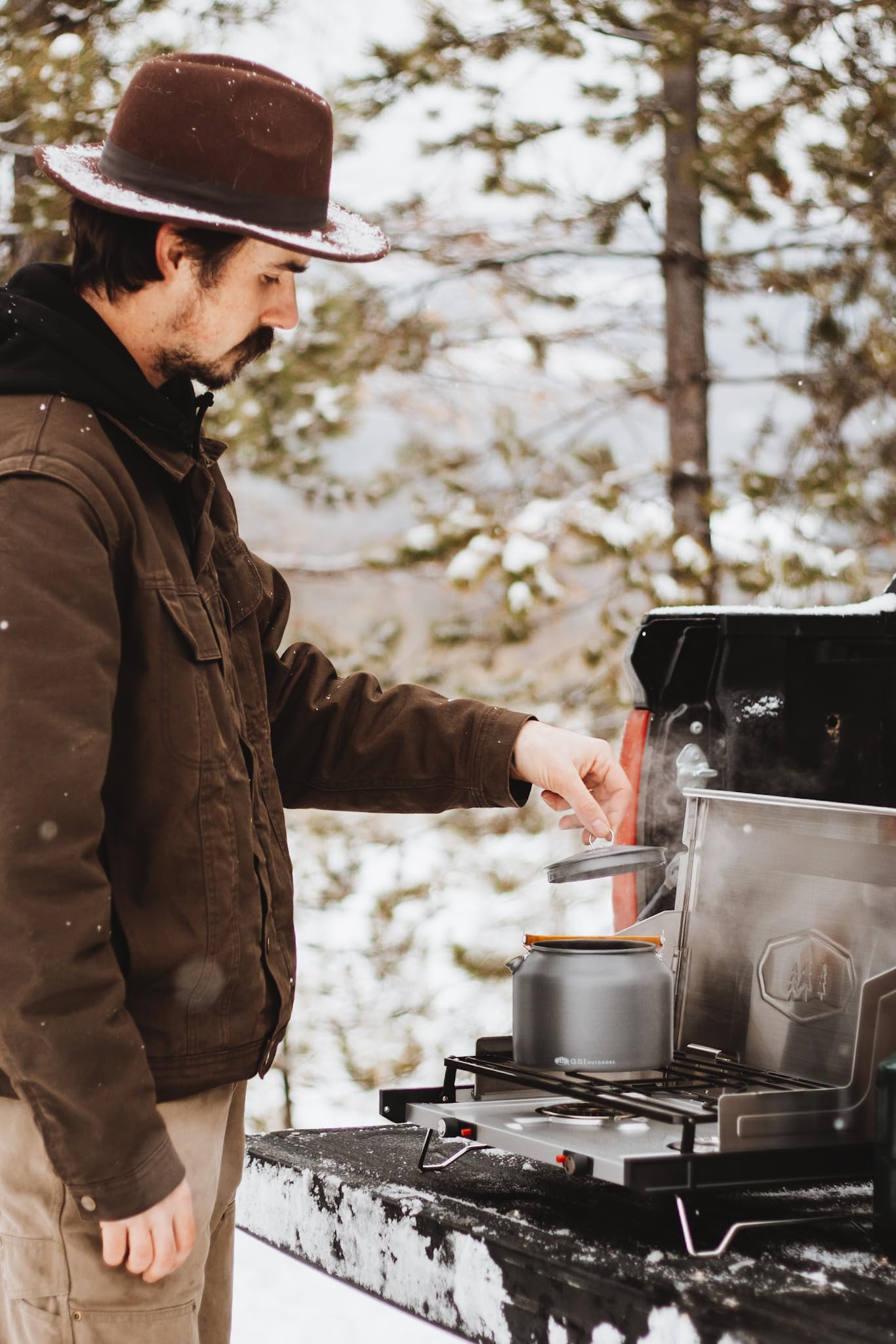 Kettle in camp kitchen setup for efficient outdoor cooking.