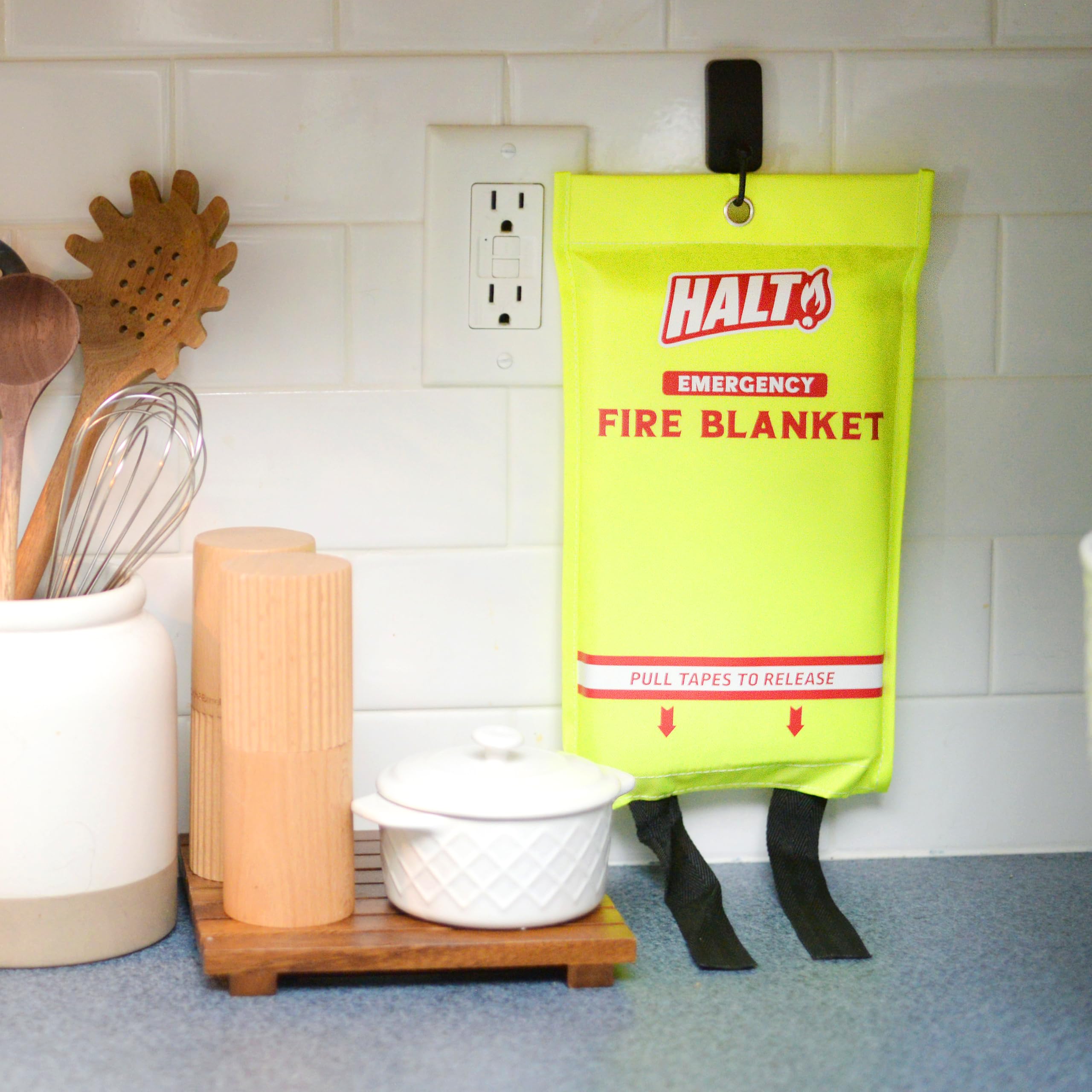HALT! fire blanket deploying with pull tabs to smother a small flame