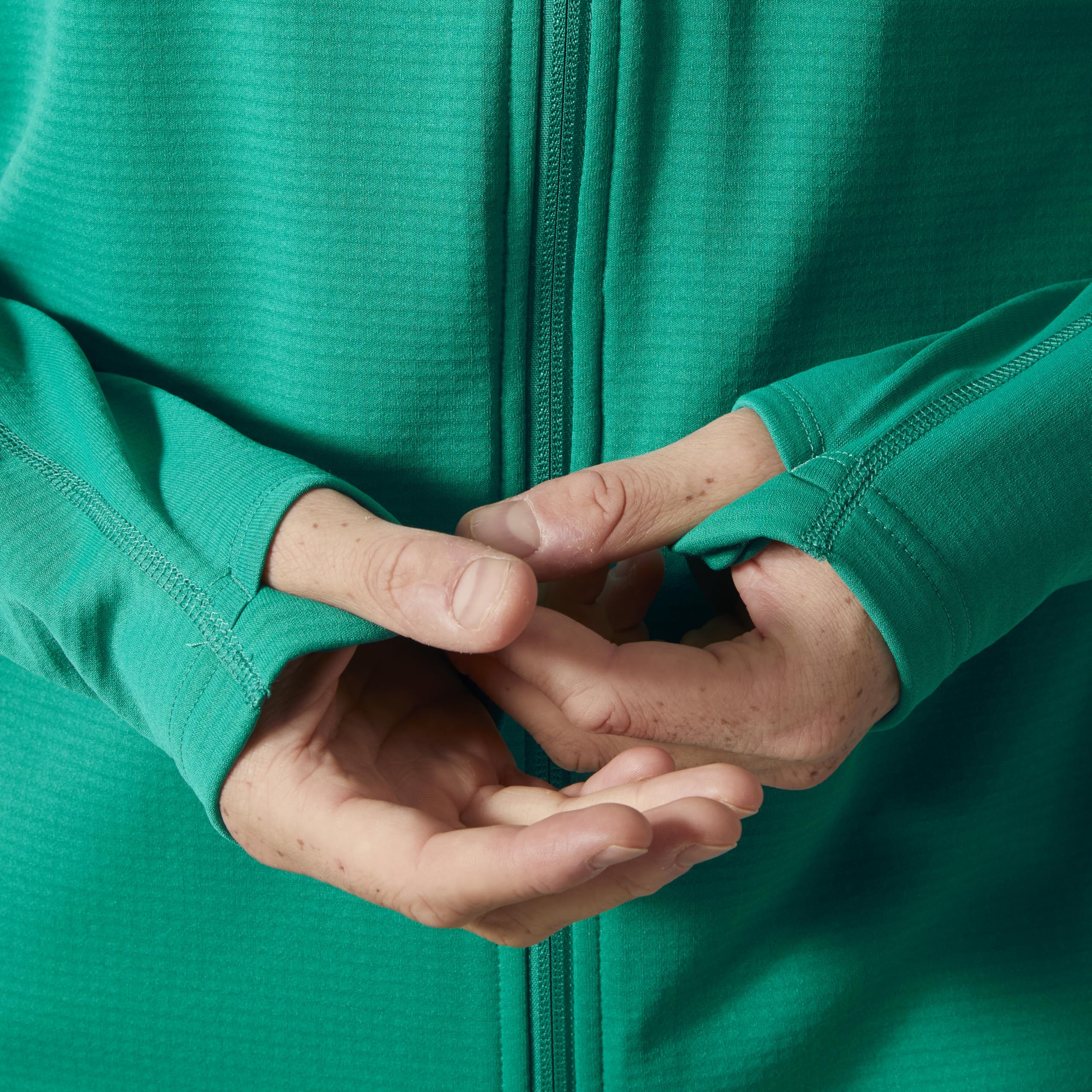 Helly-Hansen Versalite hooded fleece shows thumb holes adding warmth during chilly activities.