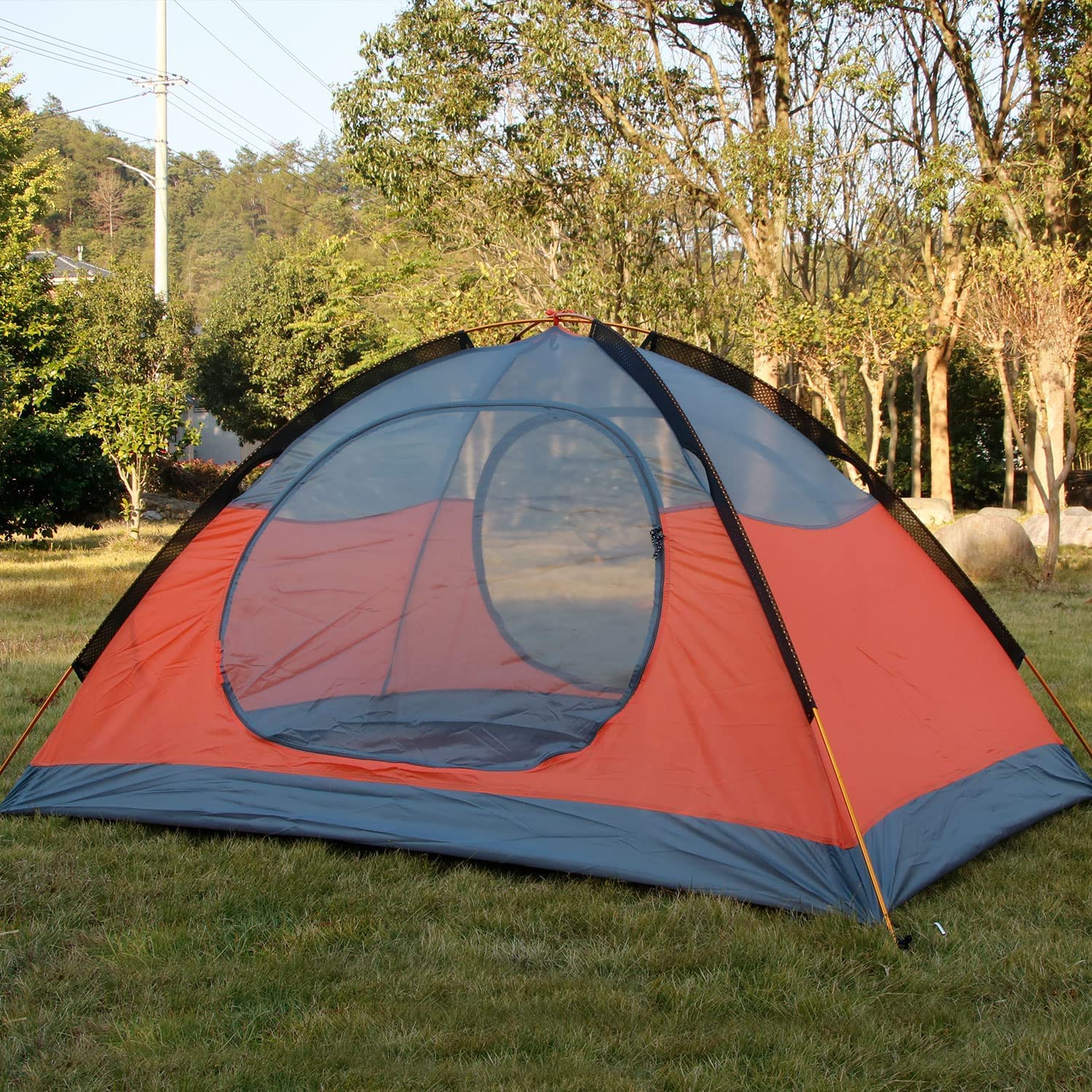 Hillman orange two-person tent in a camping setting