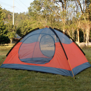 Hillman orange two-person tent in a camping setting