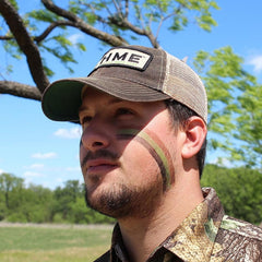 HME face paint stick applying camouflage directly on the face for quick concealment.