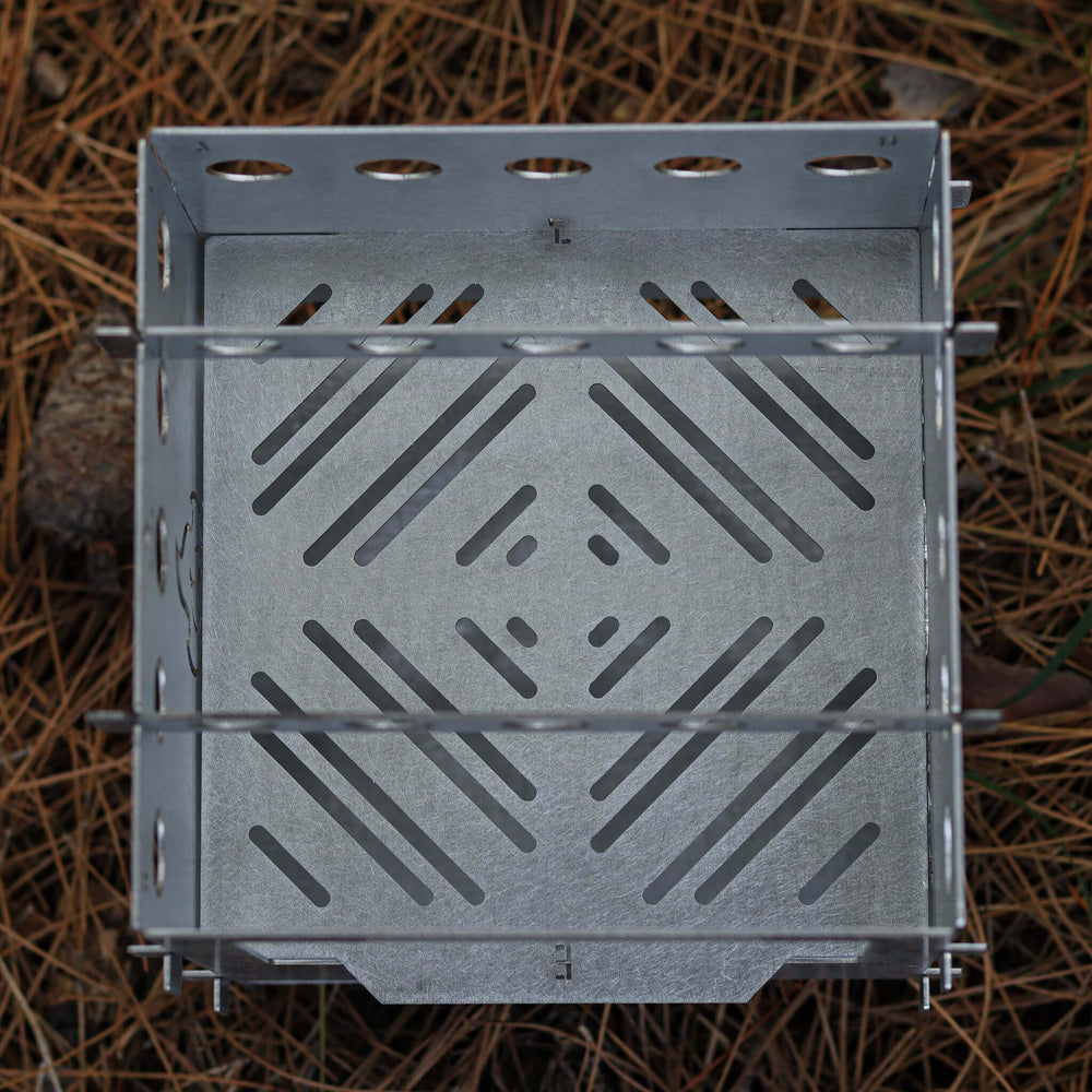 Kamp Ayisi folding camp stove showing compact storage and reliable heat in action.