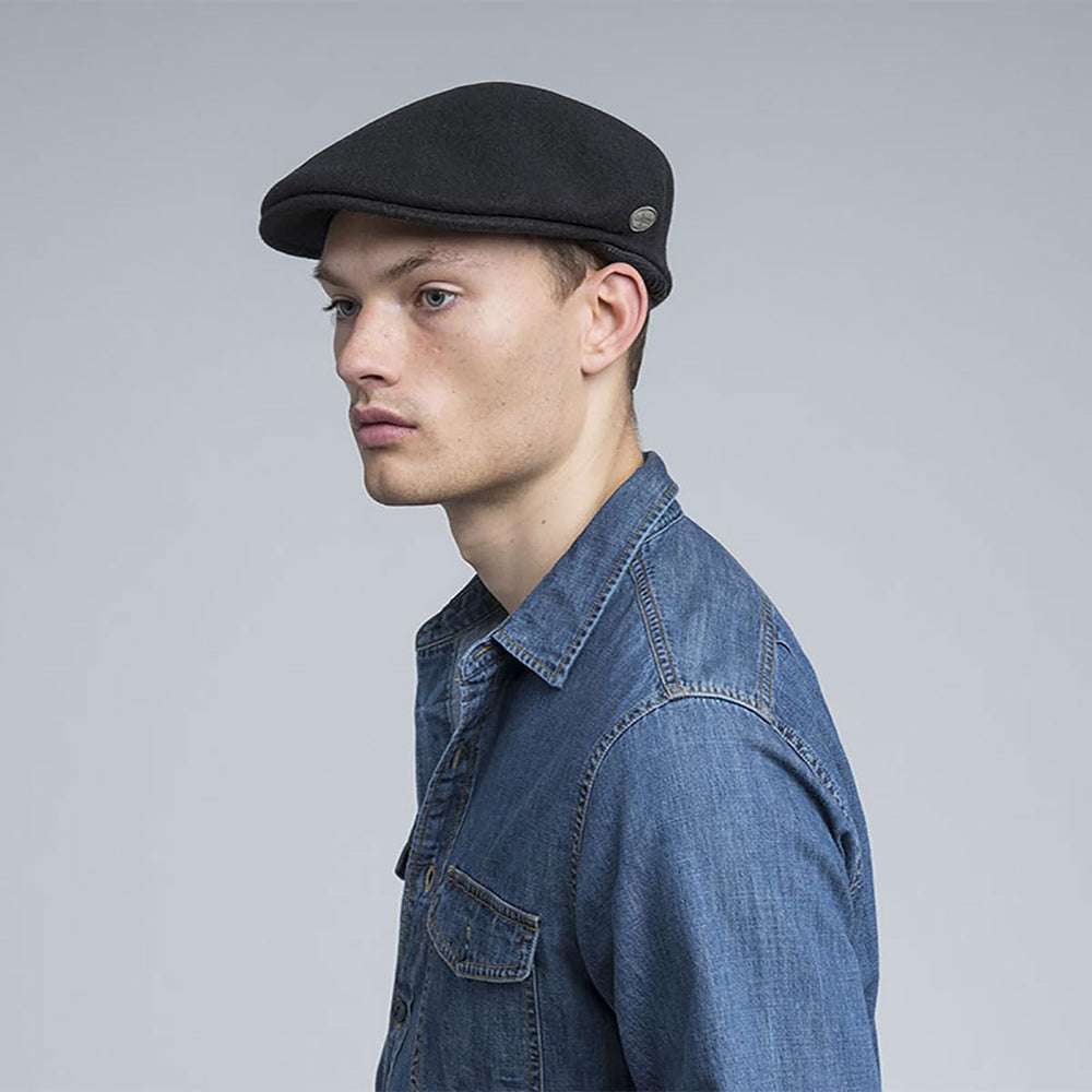 Kangol Wool 504 earflap hat worn by model demonstrating versatile styling with coats and streetwear.