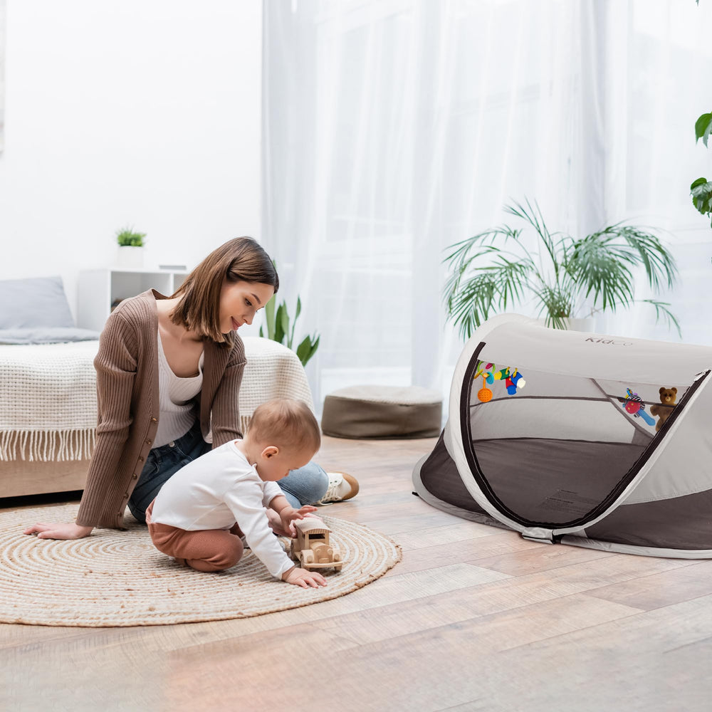 Anchor straps on KidCo Peapod securing outdoors on grass