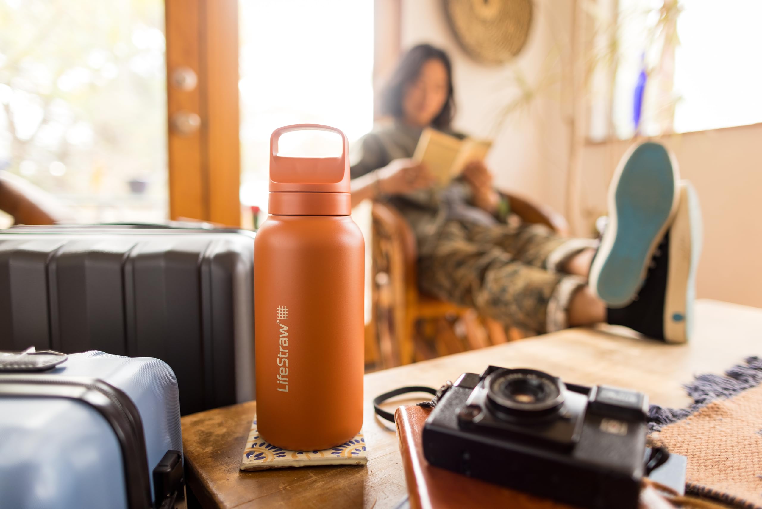 LifeStraw Go bottle with water in glass shows refreshing hydration on the move.
