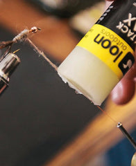 Loon Swax High Tack with push-bottom cap for easy, controlled application.