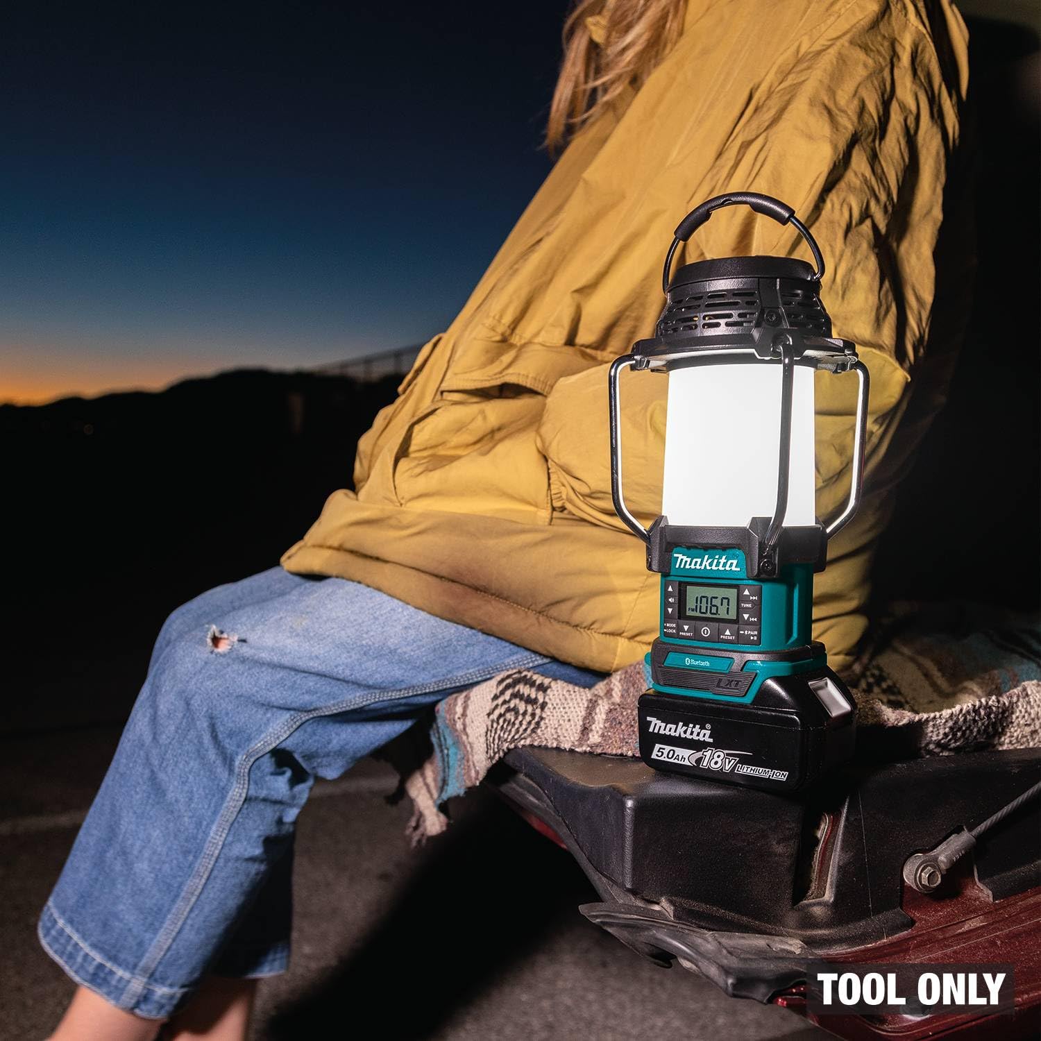 Makita XRM13 FM radio and lantern combo on a workbench.
