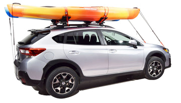 Malone SeaWing with bow and stern tie-downs securing kayak for highway transport.