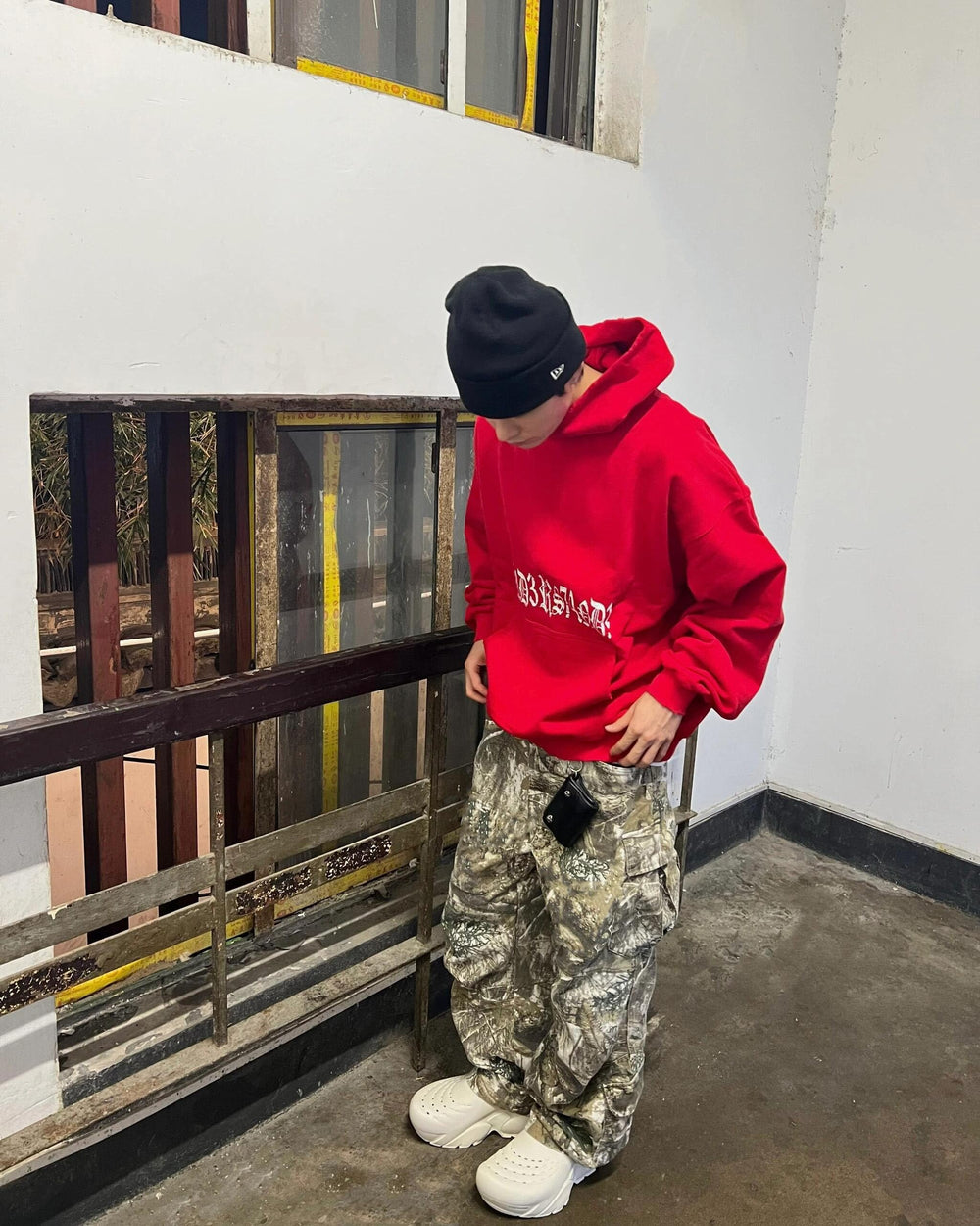 Styled image of MIFJNF camo cargo pants in outdoor streetwear look.