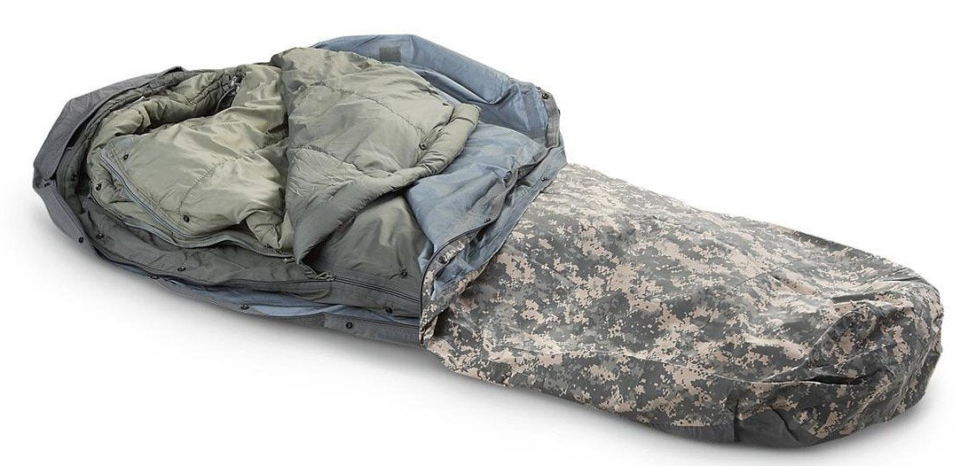 Military Outdoor Clothing ACU digital modular sleeping bag system in foliage, field-ready and adaptable for overnight trips.