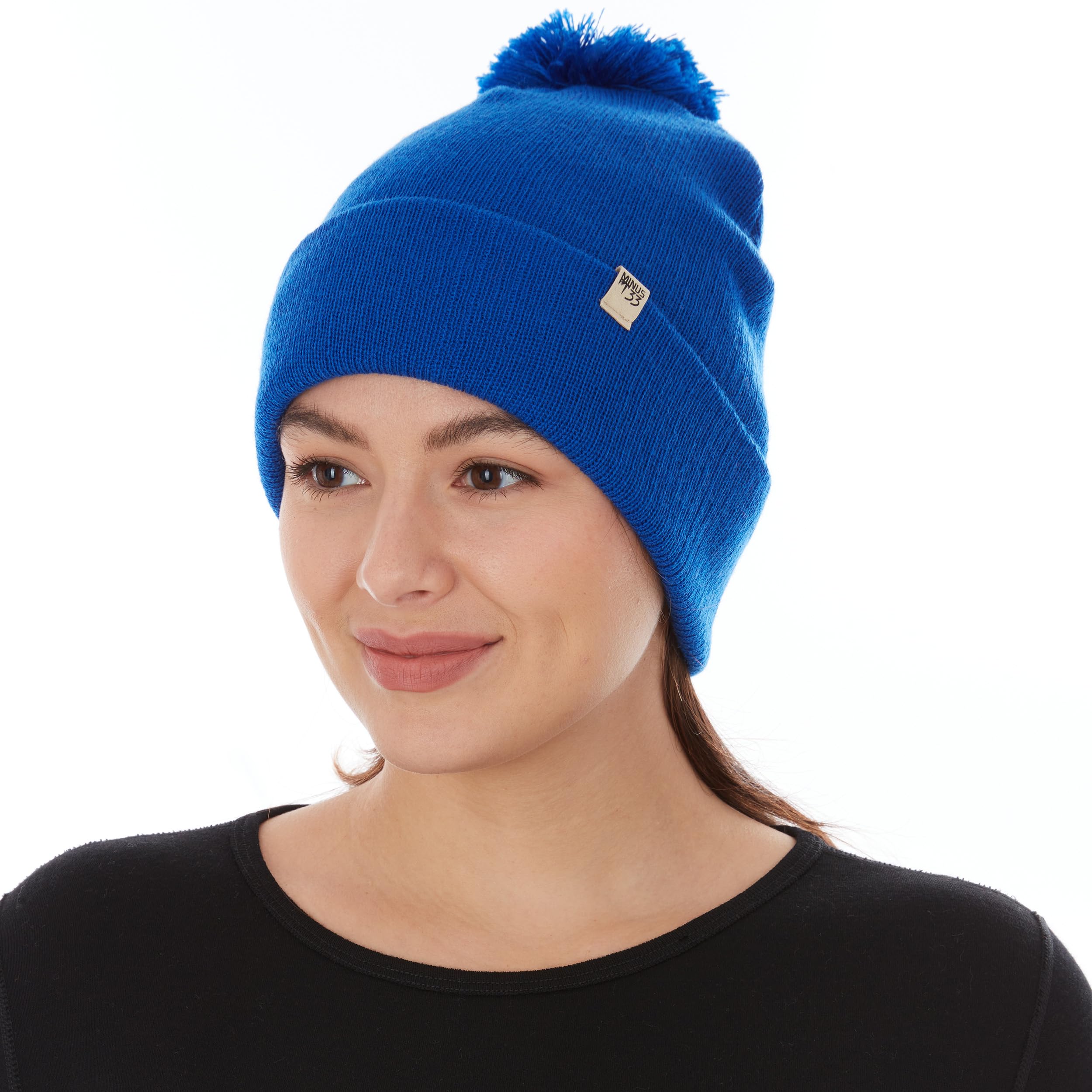 Minus33 Merino midweight pom beanie royal blue side view for versatile wear.