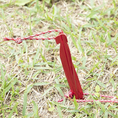 MSR Cyclone 10-inch red stake inserted into soft soil for anchoring.
