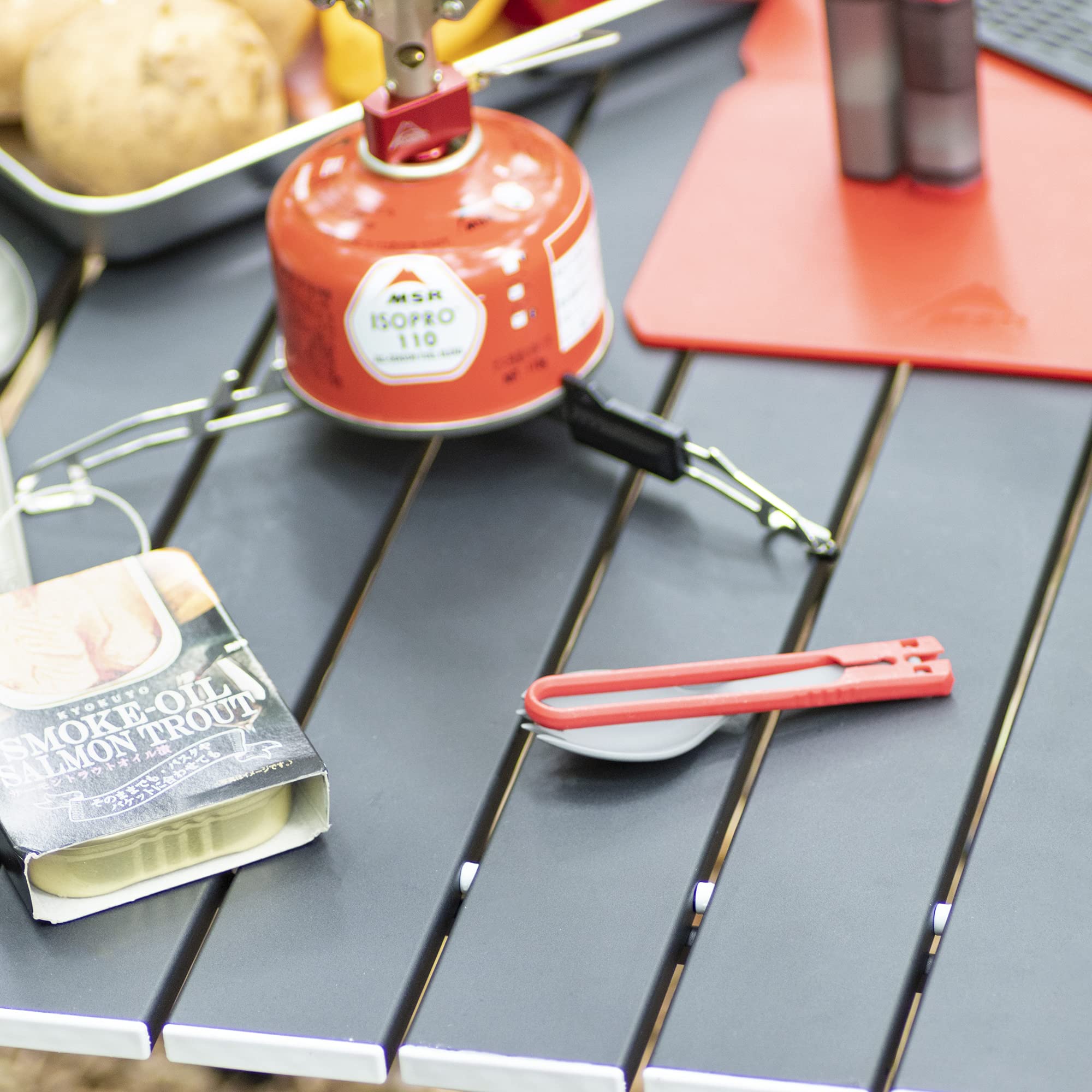 MSR folding camping spork open in red, convenient for quick meals on trails
