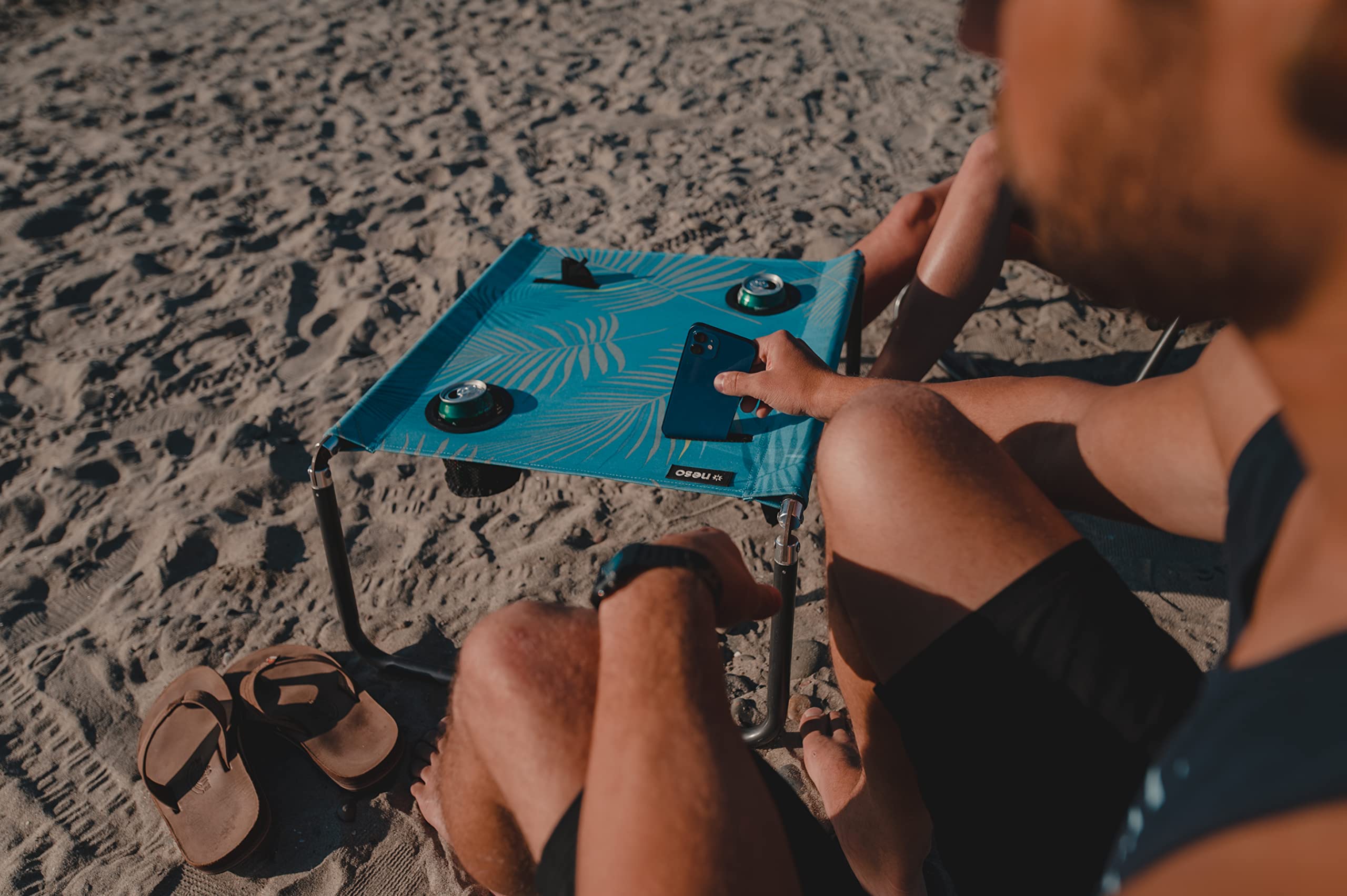 Neso Beach Table cup holder and phone pocket keep essentials handy.