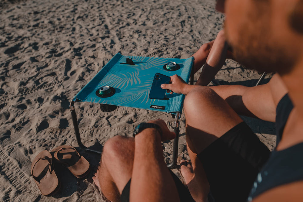Neso Beach Table cup holder and phone pocket keep essentials handy.