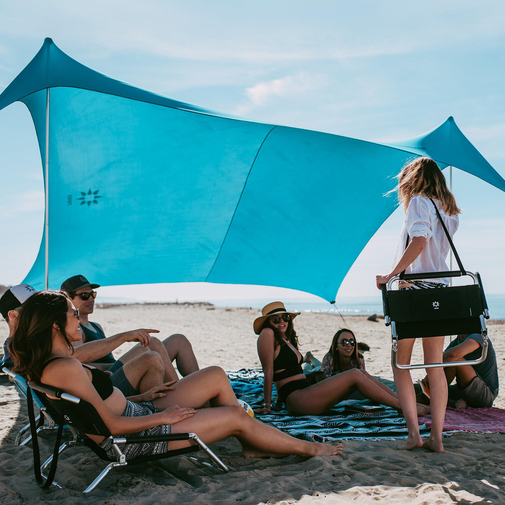 Neso Gigante beach tent assembly shows quick shade setup for a family day by the shore.