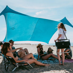 Neso Gigante beach tent assembly shows quick shade setup for a family day by the shore.