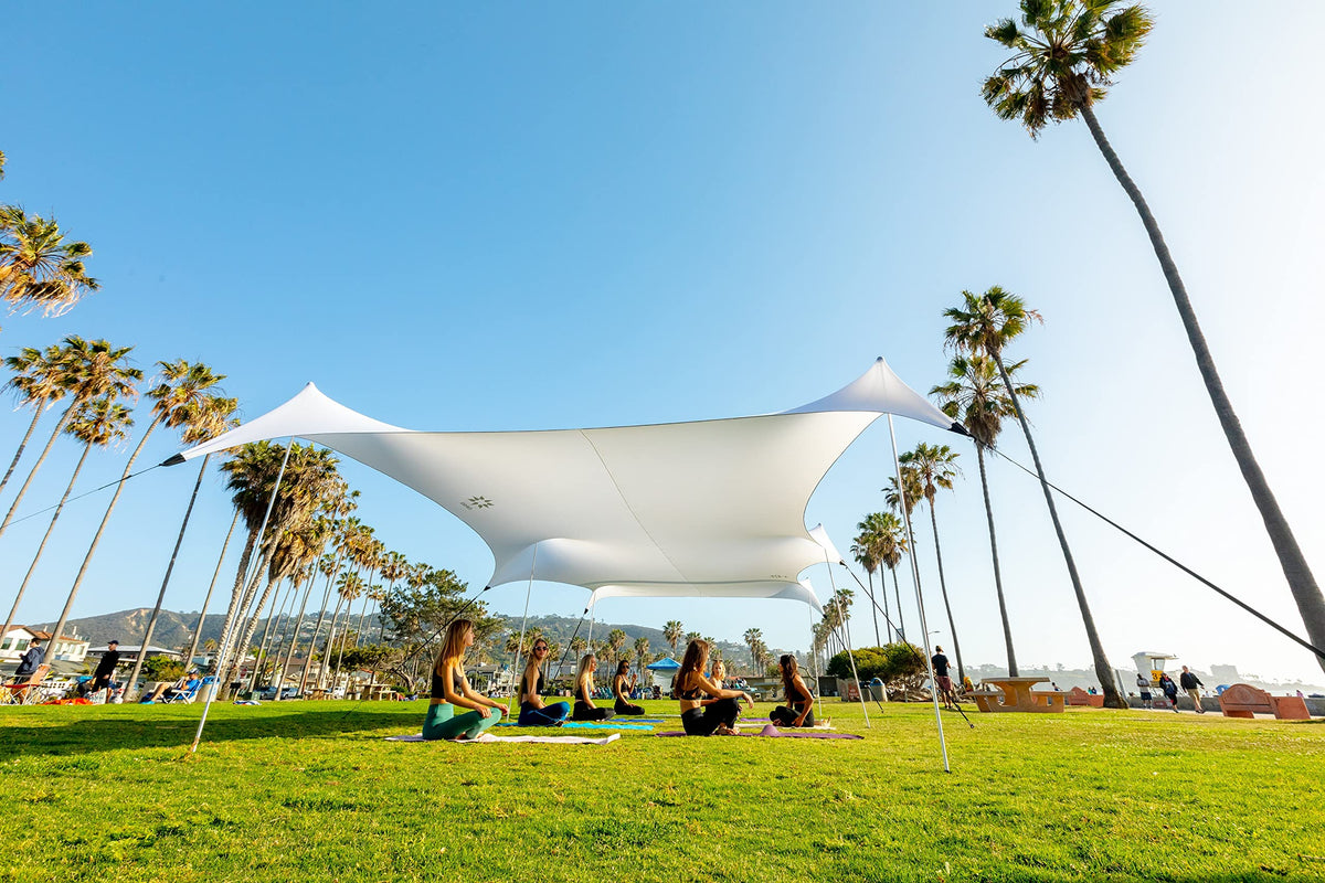 Neso Party Tent 11x22ft on the beach, stable shade for sun and wind.