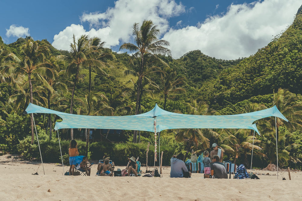 Neso Aqua Fronds party tent front view provides shaded beach space.