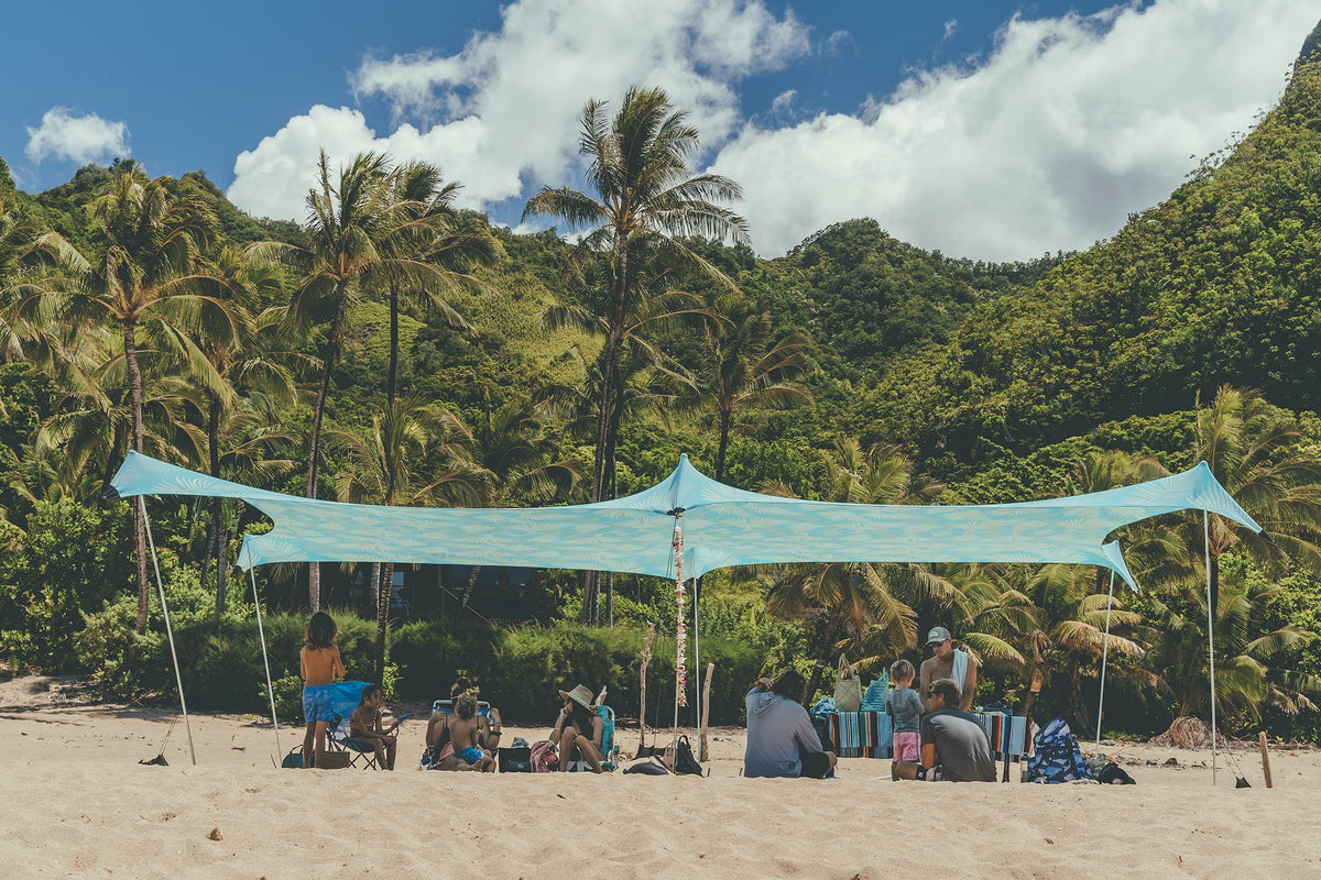 Neso Aqua Fronds party tent front view provides shaded beach space.