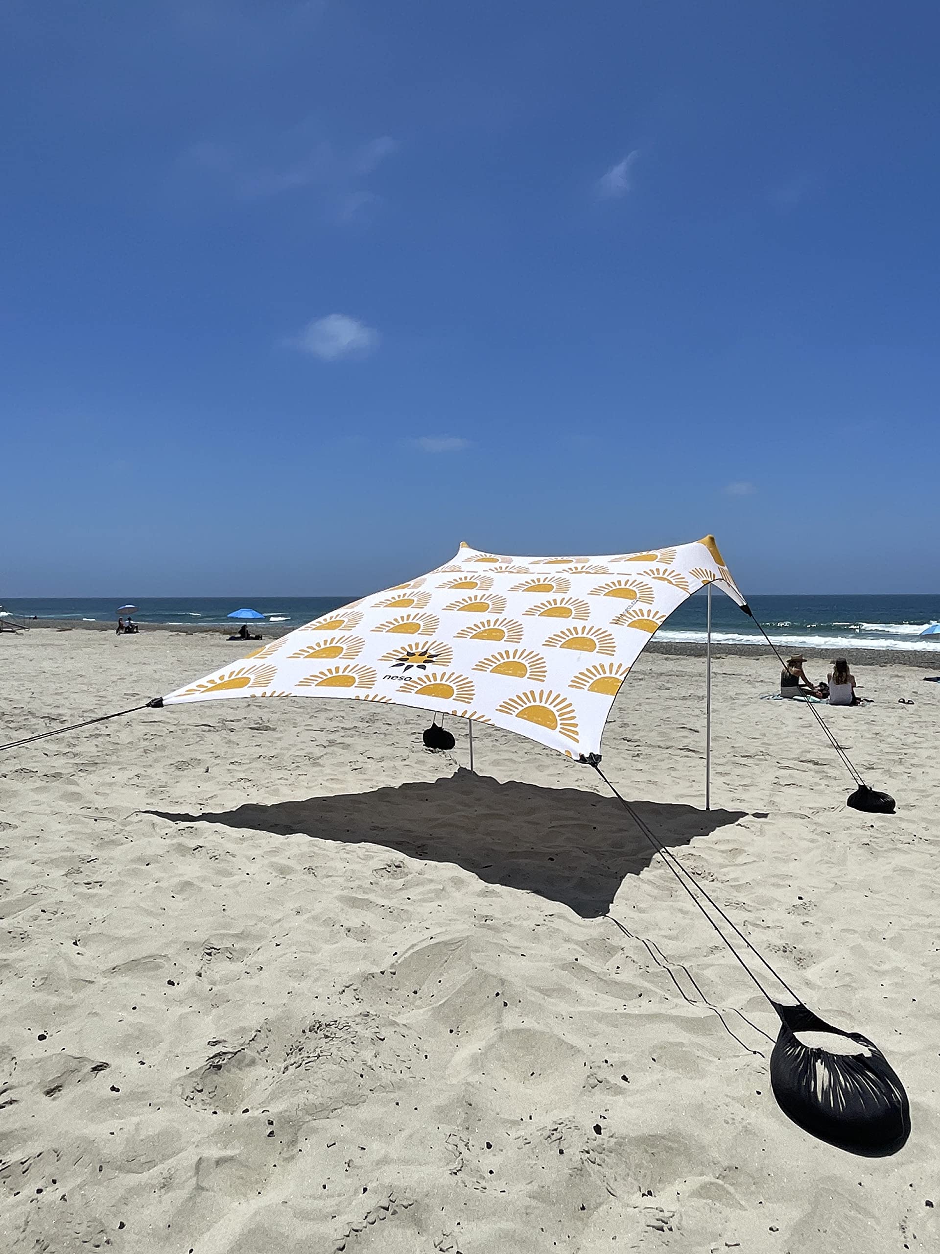 Neso sand anchor bags stabilizing the canopy for stable beach shade.