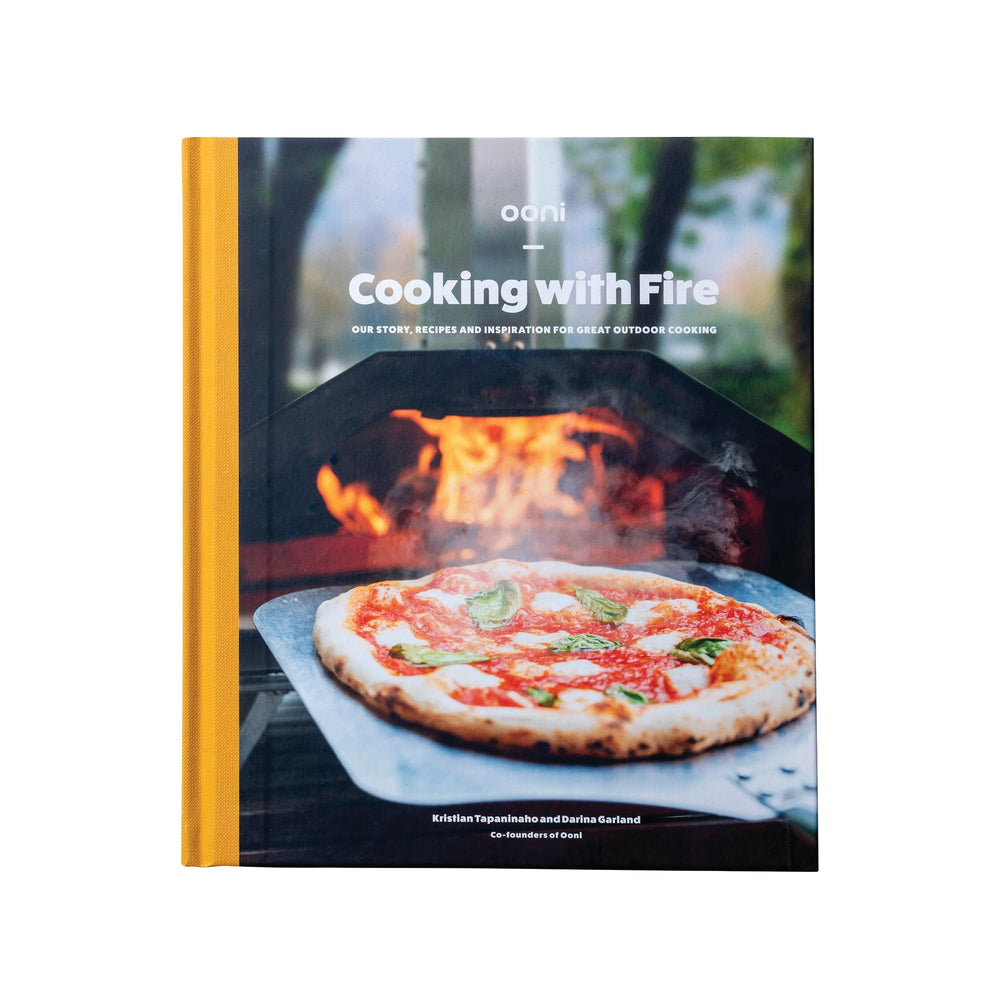 Ooni Cooking with Fire cover showcasing outdoor cooking inspiration for backyard chefs.
