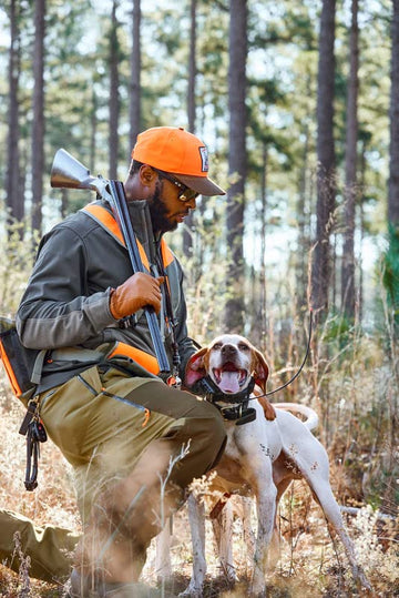 Model wearing Orvis Uplander gloves in rugged upland terrain