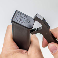 Close-up of Glock magazine base plate removal with Otis tool