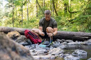 Pacific Bay pump shown in outdoor use for hiking and camping water needs.