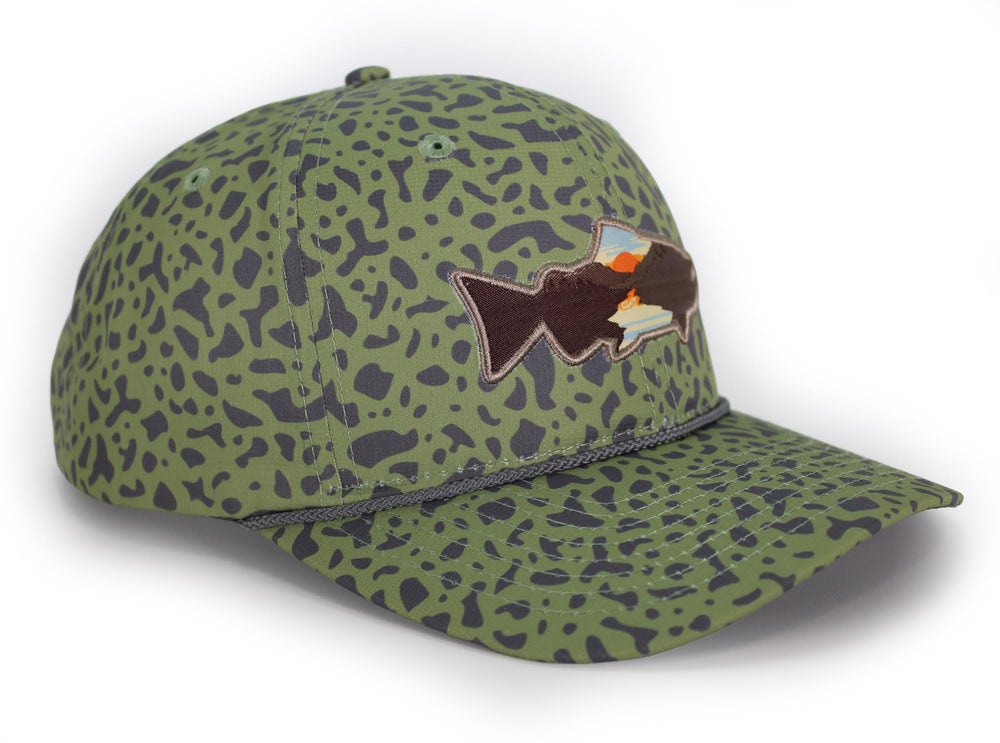 Paramount Outdoors Sunset Trout hat worn by angler on riverbank.