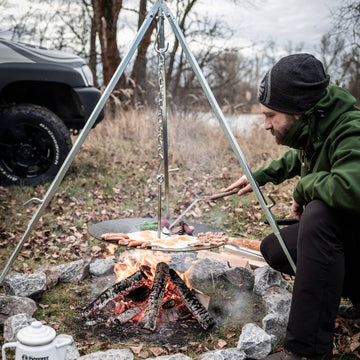 Petromax stable tripod on uneven terrain enhances outdoor cooking safety.