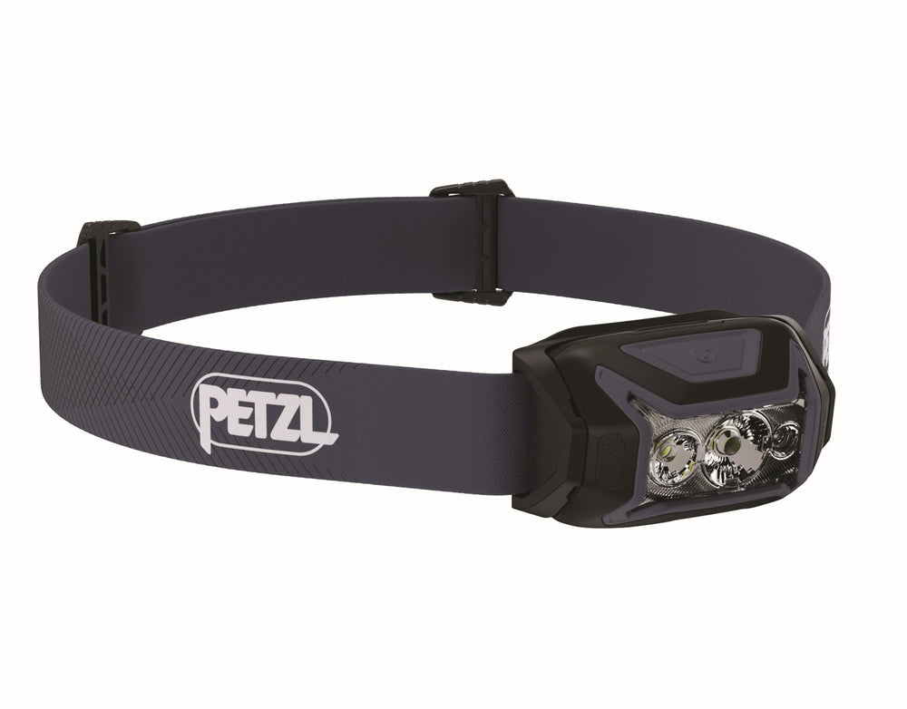 PETZL ACTIK headlamp on forest trail provides hands-free lighting for night hikes.