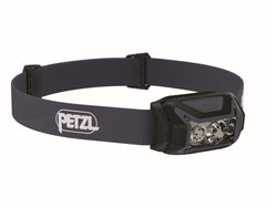 PETZL ACTIK headlamp on forest trail provides hands-free lighting for night hikes.